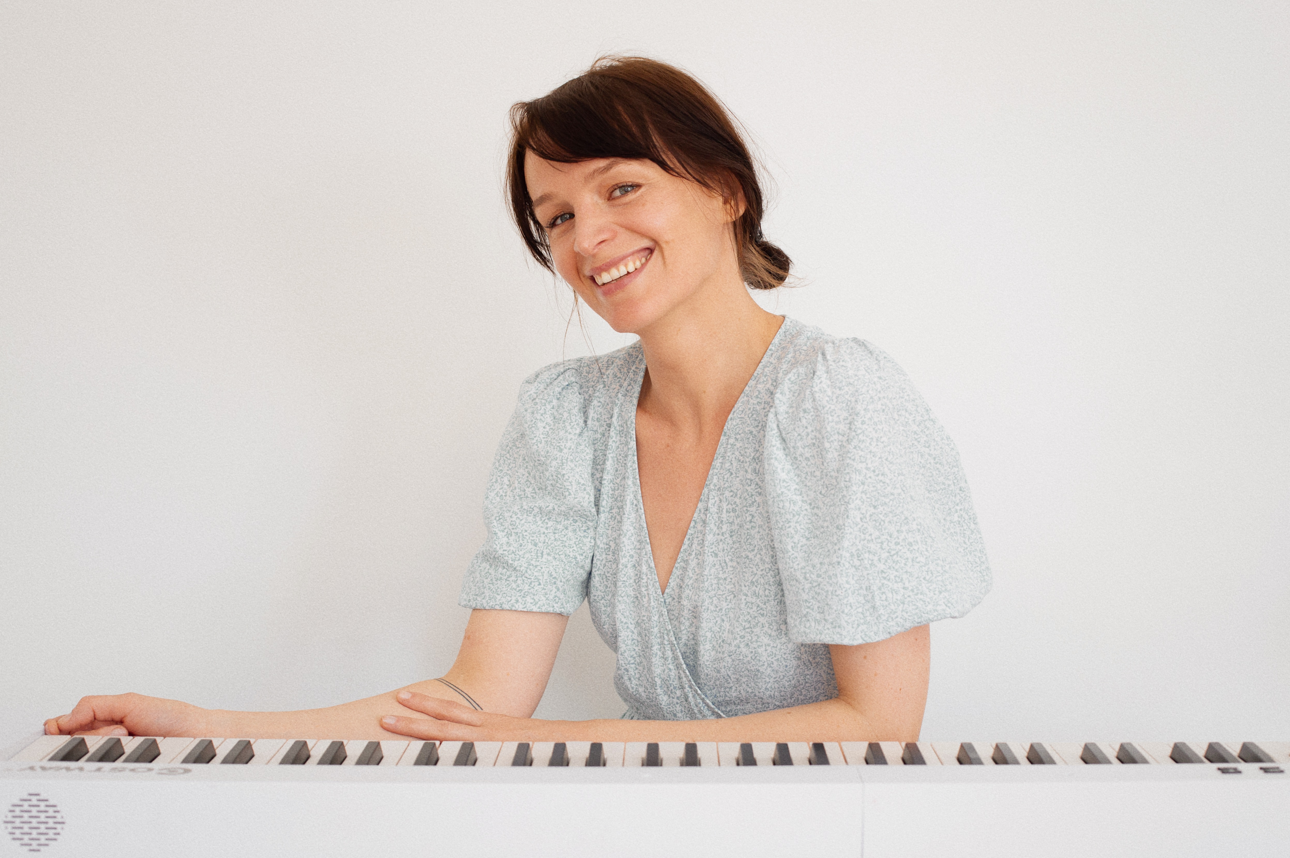 At the piano smiling